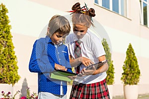 The children show each other something on the tablets in the sch