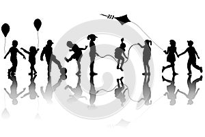 Children silhouettes playing with a kite and balloons
