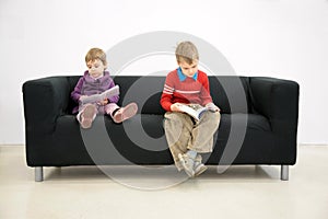 Children sit on couch and read