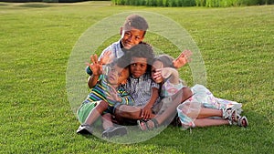 Children sit on a green lawn.