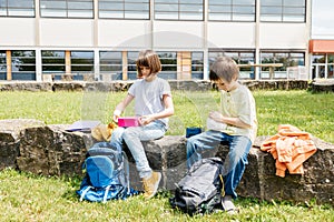 Children sit on in the school yard and eat apples and sandwiches. Snack during break time during class