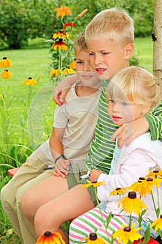 Children sitting on bench in garden