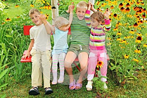 Children sitting on bench in garden