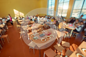 Children sitting at cafeteria table while eating lunch