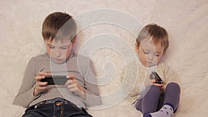 Children sitting on the couch playing on your tablet and phone