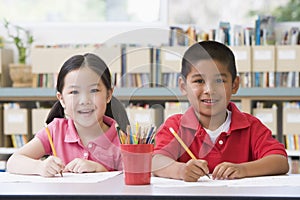 Children sitting at desk and writing in classroom
