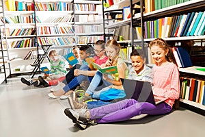 Children sitting on floor in library and studying