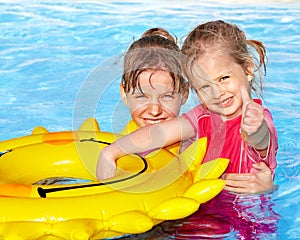 Children sitting on inflatable ring..