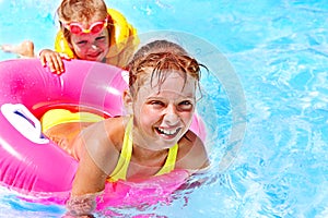 Children sitting on inflatable ring.