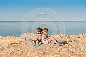 Children sitting at a sea shore