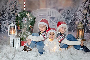 Children, sitting in the snow, wrapped in toilet paper and christmas light strings