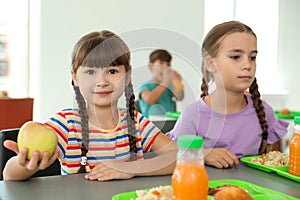 Children sitting at table and eating healthy food