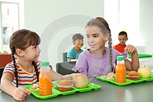 Children sitting at table and eating healthy food