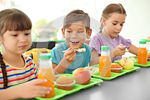 Children sitting at table and eating healthy food during break