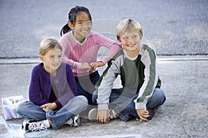 Children sitting together on driveway