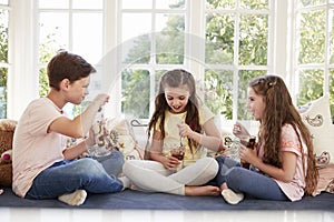 Children Sitting On Window Seat Eating Ice Cream Sundaes