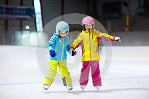 Children skating on indoor ice rink. Kids and family healthy winter sport. Boy and girl with ice skates. Active after school