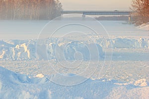 Children skating rink, a bridge and a winter fog over the frozen river.