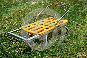 Children sledges are standing on the green grass. The concept of global warming, the lack of climate winter, I want