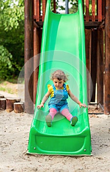 Children on slide - girl chuting down slide at playground