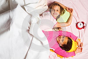Children with smiling faces lie on pink and white background