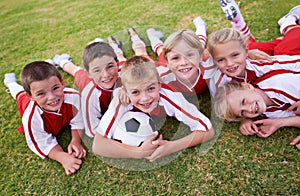 Children, soccer team and portrait with ball, boys and girls on field, happy and united. Energy, sports and friendship