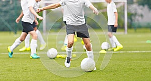 Children on Soccer Training. Group of Young Boys Kicking Football Balls on Grass Field