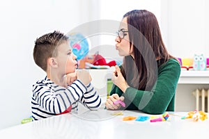 Children speech therapy concept. Preschooler practicing correct pronunciation with a female speech therapist.