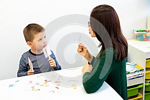 Children speech therapy concept. Preschooler practicing correct pronunciation with a female speech therapist.