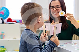 Children speech therapy concept. Preschooler practicing correct pronunciation with a female speech therapist.