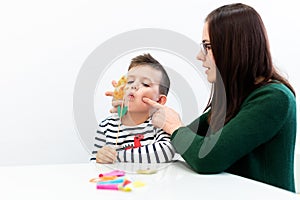 Children speech therapy concept. Preschooler practicing correct pronunciation with a female speech therapist.