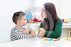 Children speech therapy concept. Preschooler practicing correct pronunciation with a female speech therapist.