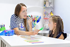 Children speech therapy concept. Preschooler practicing correct pronunciation with a female speech therapist.