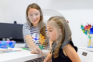 Children speech therapy concept. Preschooler practicing correct pronunciation with a female speech therapist.