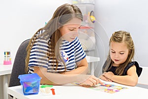 Children speech therapy concept. Preschooler practicing correct pronunciation with a female speech therapist.