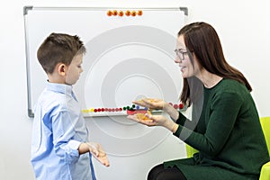 Children speech therapy concept. Preschooler at speech therapy doing breathing exercises with a female speech therapist.