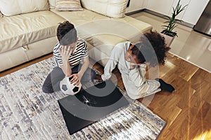 Children standing in front of a TV with broken screen holding a ball. Home insurance concept