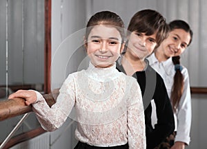 Children standing near a ballet barre