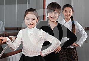 Children standing near a ballet barre