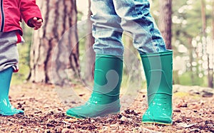 Children standing in wellies in the forest photo