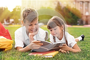 Children with stationery doing school assignment on grass