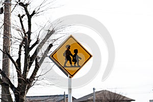 Children and students crossing road sign.