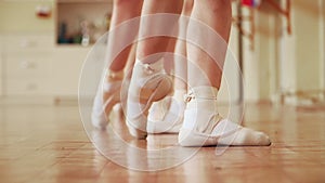 The children study ballet. Feet in Pointe shoes close-up. Slow motion.