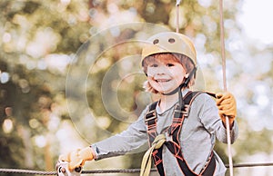 Children summer activities. Adventure climbing high wire park. Cute baby boy playing. Hiking in the rope park girl in