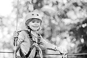 Children summer activities. Adventure climbing high wire park. Cute baby boy playing. Hiking in the rope park girl in