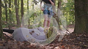 Children in a summer camp hike crawls on the ground. Training of passing obstacles by crawling on the ground. A girl