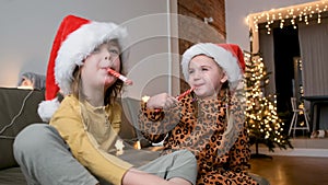 Children with sweets in santa hat in the evening at home