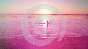 Children swim in the lake at sunset, the joy of childhood.