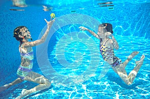 Children swim in pool underwater, happy active girls have fun under water