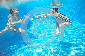 Children swim in pool underwater, happy active girls have fun under water